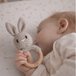 Schlafendes Baby mit einer Rassel in FOrm eines gehäkelten Hasen mit Namensgravur