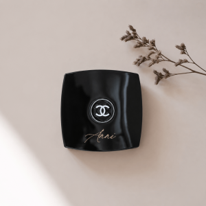 schwarzer quadratischer Spiegel mit Chanel Logo und Namensgravur "Anni" in einem minimalistischen Hintergrund