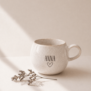 große beige Tasse mit Namensgravur "Anna" mit Herz in einem neutralen Hintergrund