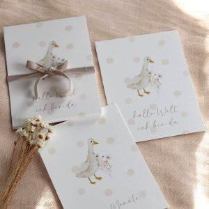 Weiße Papierkarten in Postkartenformat mit dem Aquarelldesign einer Gans auf einem beigen Leinentuch und natürlichem Sonnenlicht