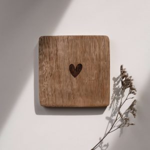 Quadratischer Untersetzer aus Mangoholz mit einem Herz in der Mitte in einem neutralen Hintergrund