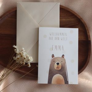 Grußkarte im Postkarten format mit Bärenmotiv und Namen daneben einer beiger Umschlag auf einem Holztablett und Trockenblumen