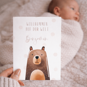 Glückwunschkarte "Willkommen auf der Welt Benjamin" mit Bärenaquarell und Punkten, im Hintergrund ein schlafendes baby