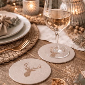 Untersetzer aus hellem Kunstleder mit Rentiermotiv auf einem weihnachtlich gedeckten Tisch