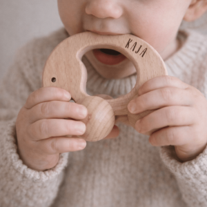 Kleinkind mit personalisiertem Greifling aus Holz in Form eines Elefants