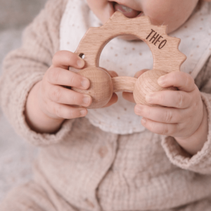 Kleinkind mit personalisiertem Greifling aus Holz in Form eines Igels
