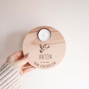 Runder Holzteller aus hellem Buchenholz mit dem Motiv einer Taube und dem Text "Anton, meine Konfirmation", von einer Hand gehalten vor einem neutralen Hintergrund
