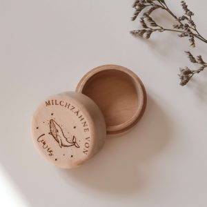 Runde helle Holzdose mit einem Namen und einem Wal Motiv vor neutralem Hintergrund