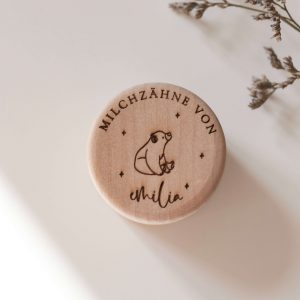 Runde helle Holzdose mit einem Namen und einem Bär Motiv vor neutralem Hintergrund