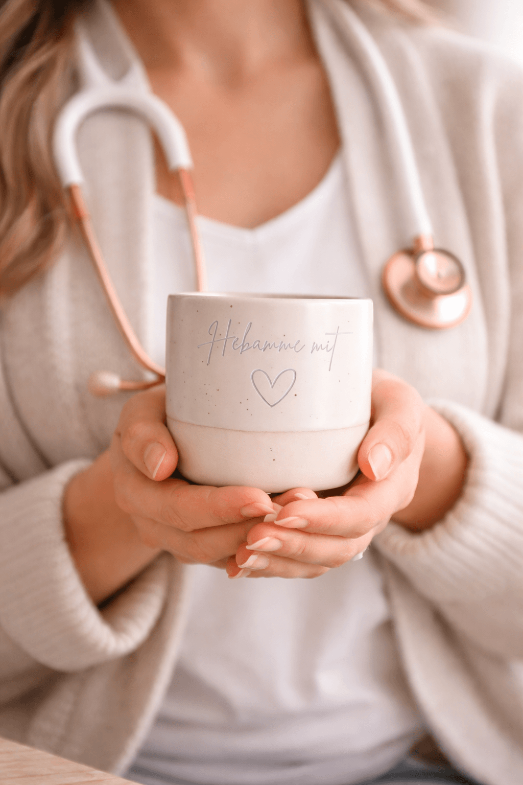 Hebamme mit einer beigen Tasse in der Hand mit der Gravur "Hebamme mit Herz"