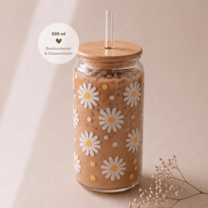 Glas mit Bambusdeckel und Strohhalm, gefüllt mit Eiskaffee, verziert mit sommerlichem Blumen-Design und weißen Blüten, auf hellem Holztisch in warmem, minimalistischem Setting