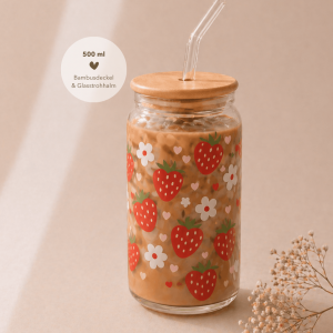 Glas mit Bambusdeckel und Strohhalm, gefüllt mit Eiskaffee, verziert mit sommerlichem Erdbeeren-Design und weißen Blüten, auf hellem Holztisch in warmem, minimalistischem Setting