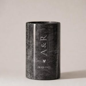 Personalisierter Sektkühler aus schwarz-weißem Naturmarmor mit gravierten Initialen und Datum. Der elegante Flaschenkühler steht vor einem hellen, minimalistischen Hintergrund und überzeugt durch seine einzigartige natürliche Maserung.