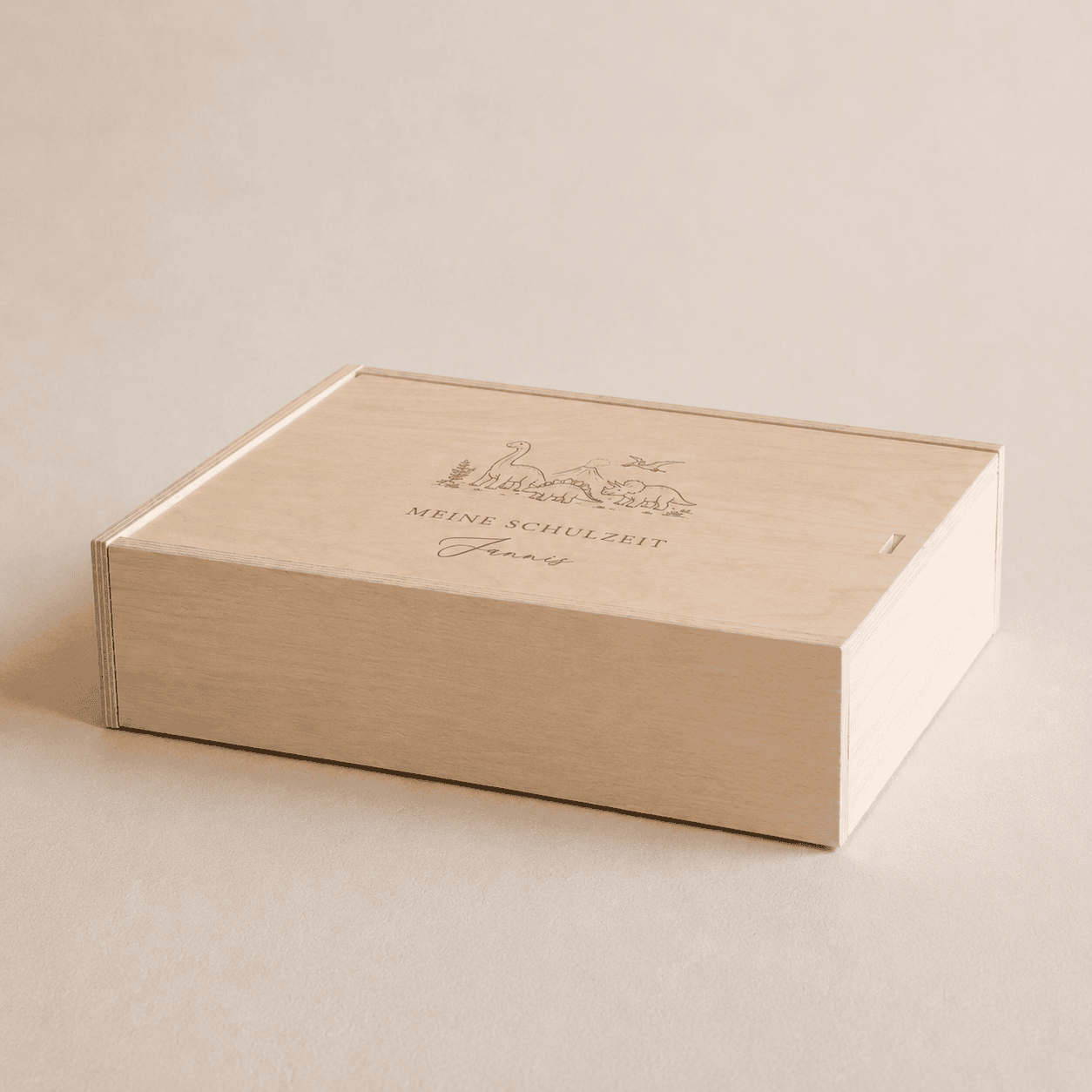 Personalisierte Erinnerungsbox aus hellem Holz mit dem eingravierten Text "Meine Schatzkiste" und einem Dinosaurier Szenario als Design auf einem minimalistischen, cremefarbenen Hintergrund mit weichem Tageslicht.