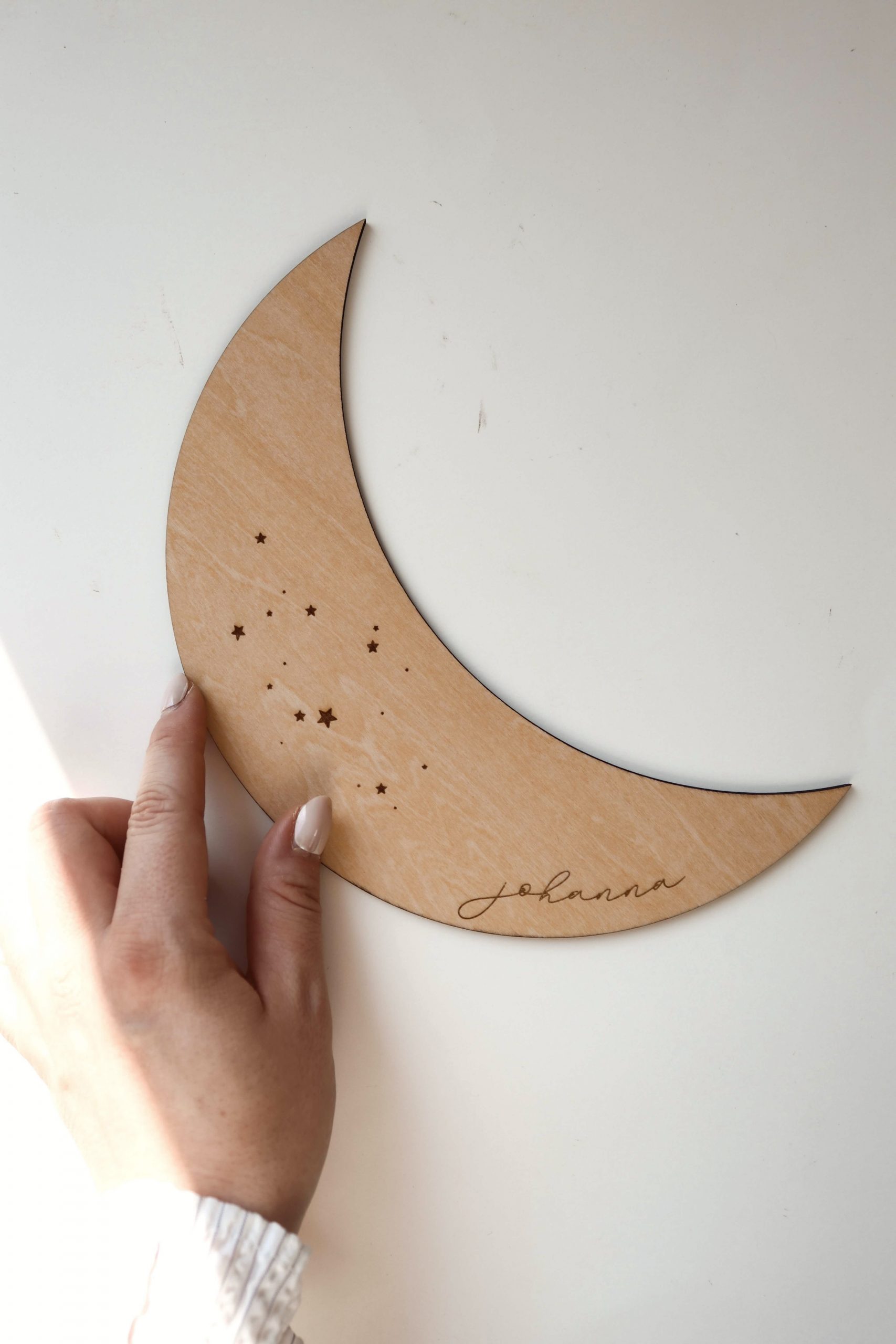 personalisiertes Holzschild in Form eines Mondes mit eingravierten Sternen und dem Namen "Johanna"