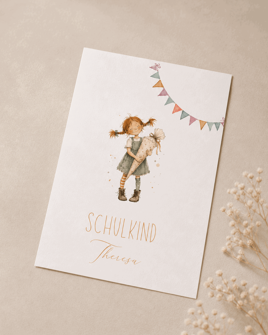 Das Foto zeigt eine Glückwunschkarte zur Einschulung mit der Aquarellzeichnung eines Mädchens, das an Pippi Langstrumpf erinnert mit einer Schultüte in der Hand. Darunter der Text "Schulkind Theresa"