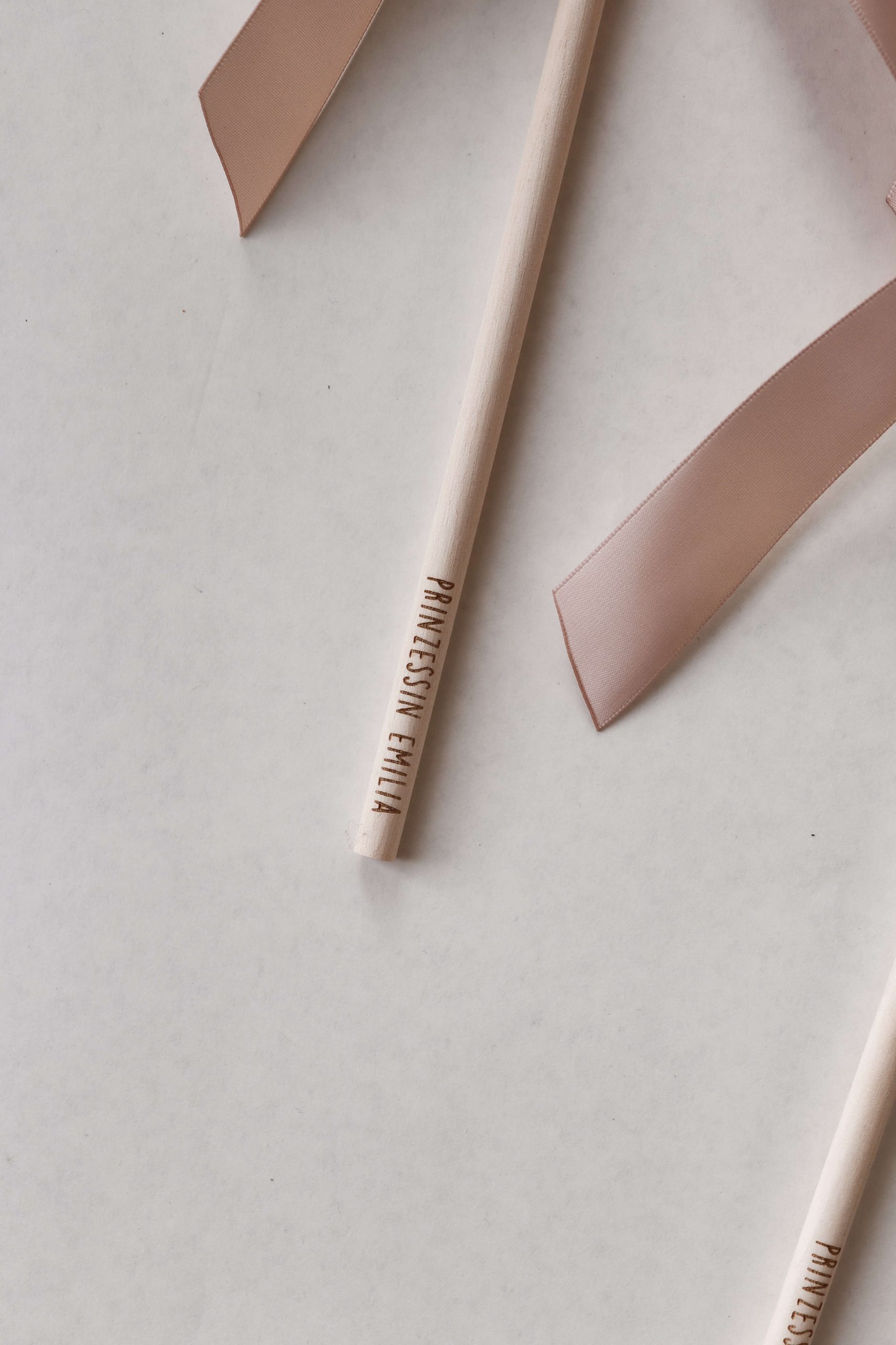 Personalisierter Prinzessinnen-Zauberstab aus Holz mit Namensgravur, wahlweise mit Mond oder Stern und dekorativem rosa Satinband.